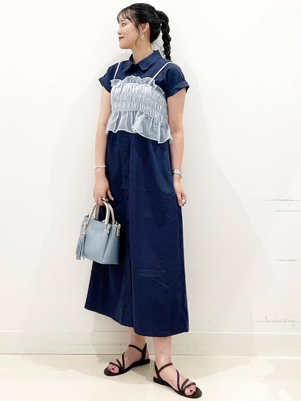 ブルー系のトートバッグ、ブラック系のサンダル、ブルー系のワンピースを着用したレディースの夏コーディネートの2枚目の写真