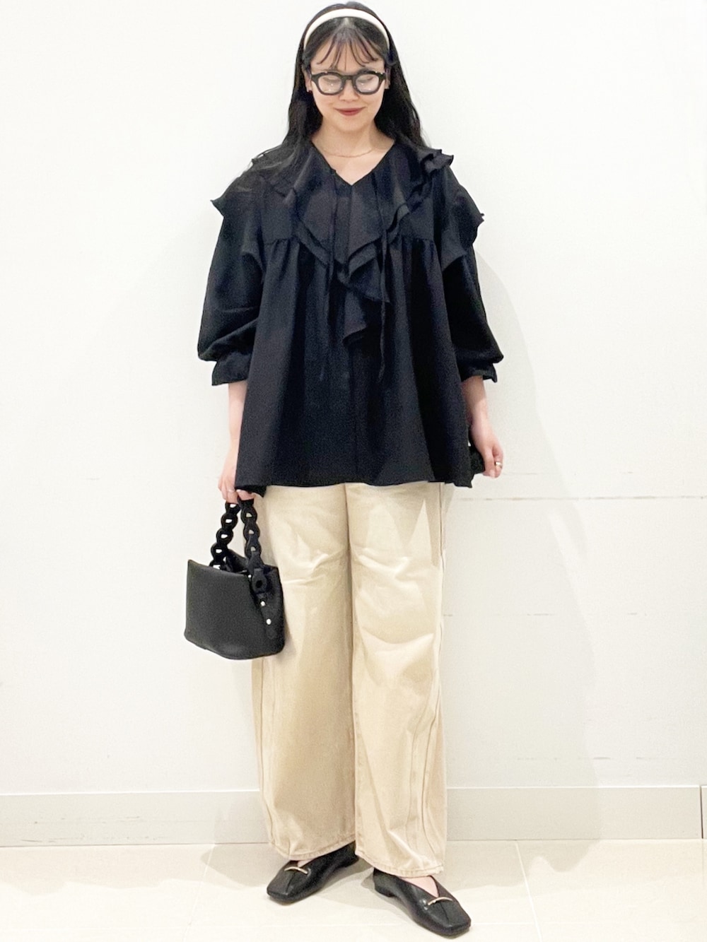 ブラック系のその他シューズ、ベージュ系のデニムパンツ、ブラック系のショルダーバッグを着用したレディースの春コーディネートの2枚目の写真