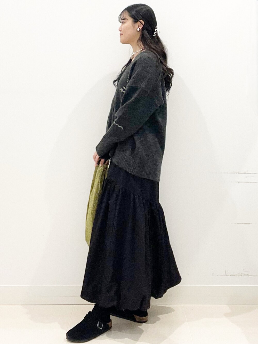 ホワイト系のTシャツ/カットソー、ゴールド系のトートバッグ、ブラック系のスカートを着用したレディースの秋コーディネートの6枚目の写真