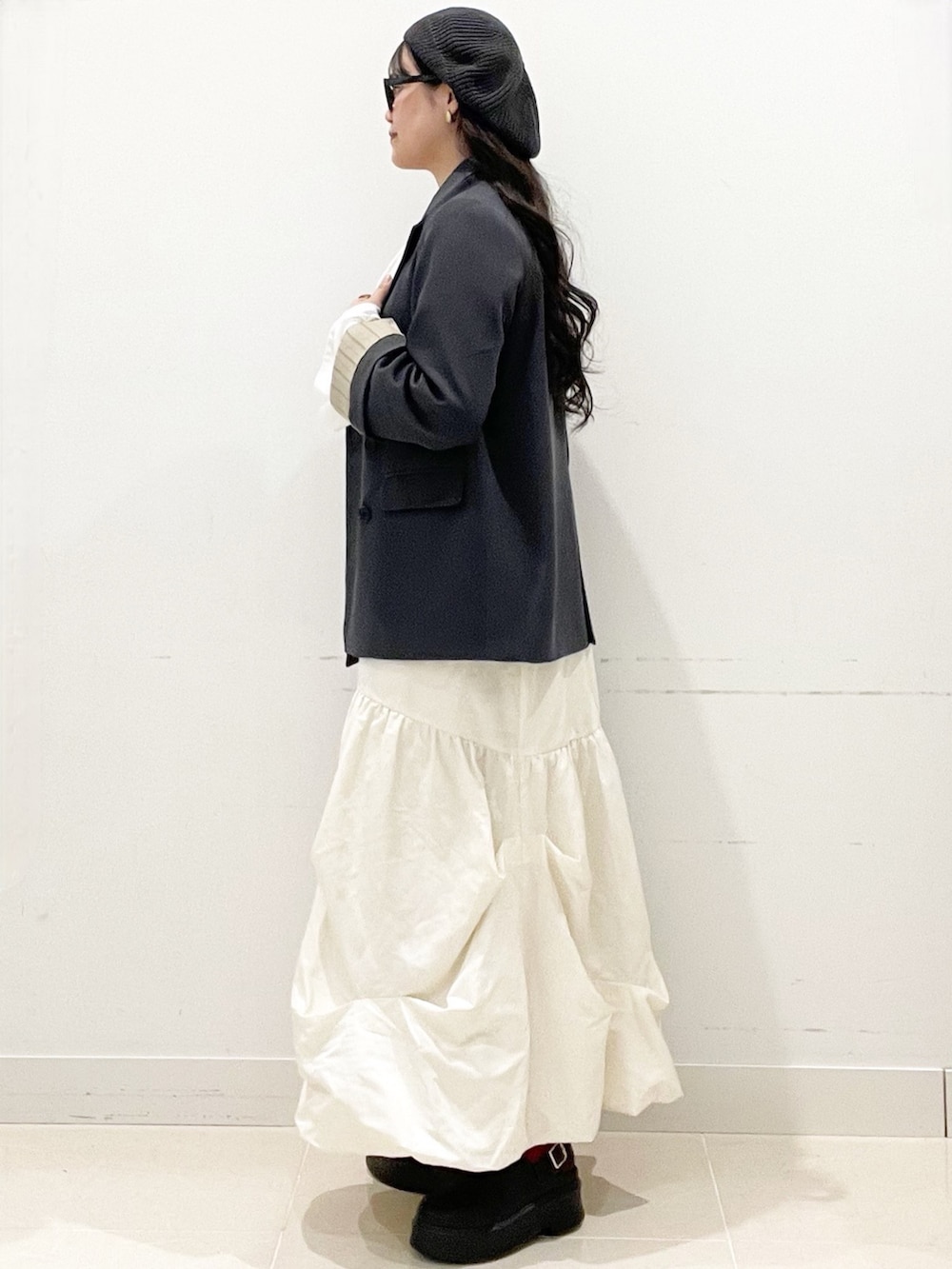 ブラック系のその他シューズ、ブラック系のハンドバッグ、ホワイト系のスカートを着用したレディースの冬コーディネートの5枚目の写真