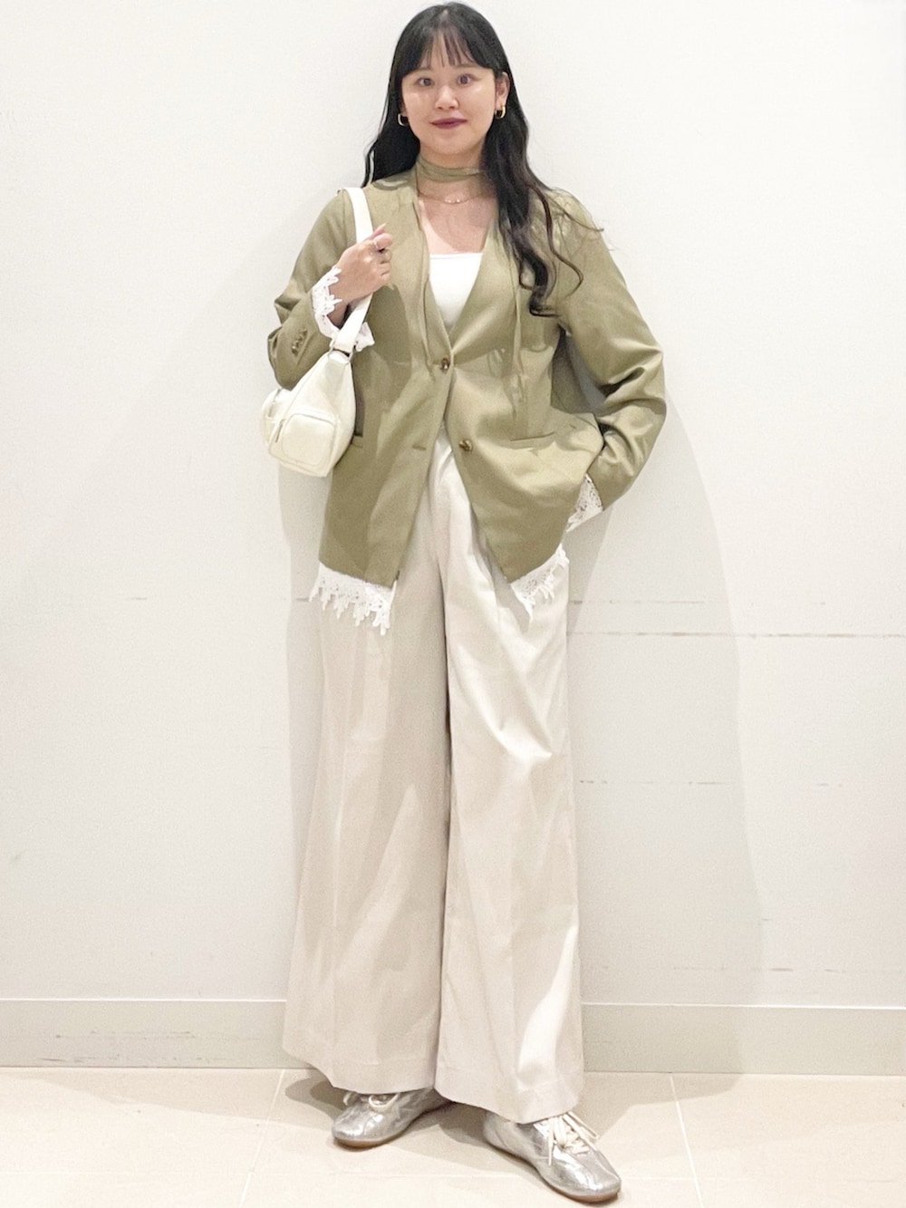 ホワイト系のチノパンツ、ベージュ系のノーカラージャケット、ホワイト系のショルダーバッグを着用したレディースの春コーディネートの4枚目の写真