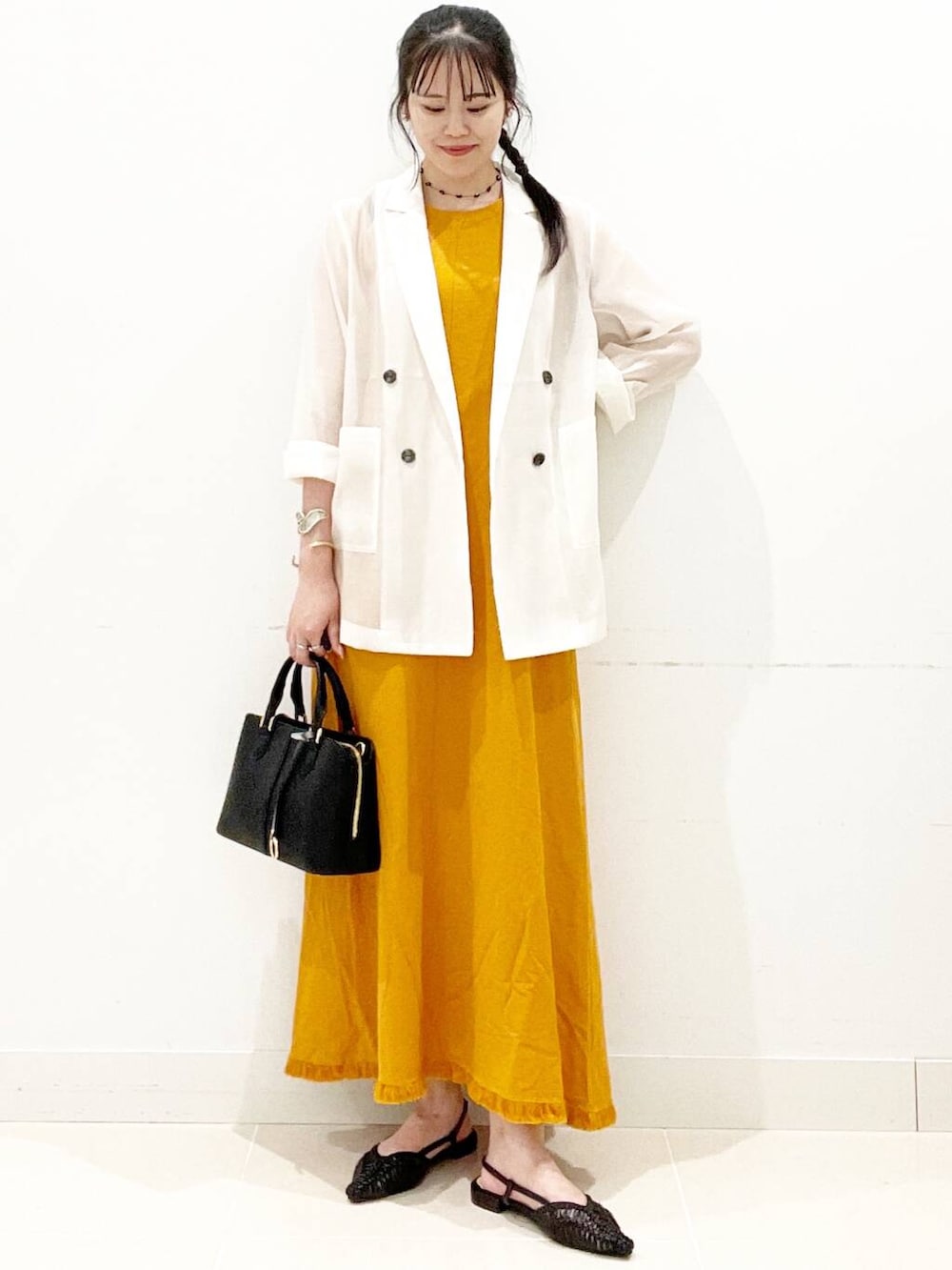 ブラック系のハンドバッグ、ブラック系のサンダル、ホワイト系のその他アウターを着用したレディースの夏コーディネートの4枚目の写真