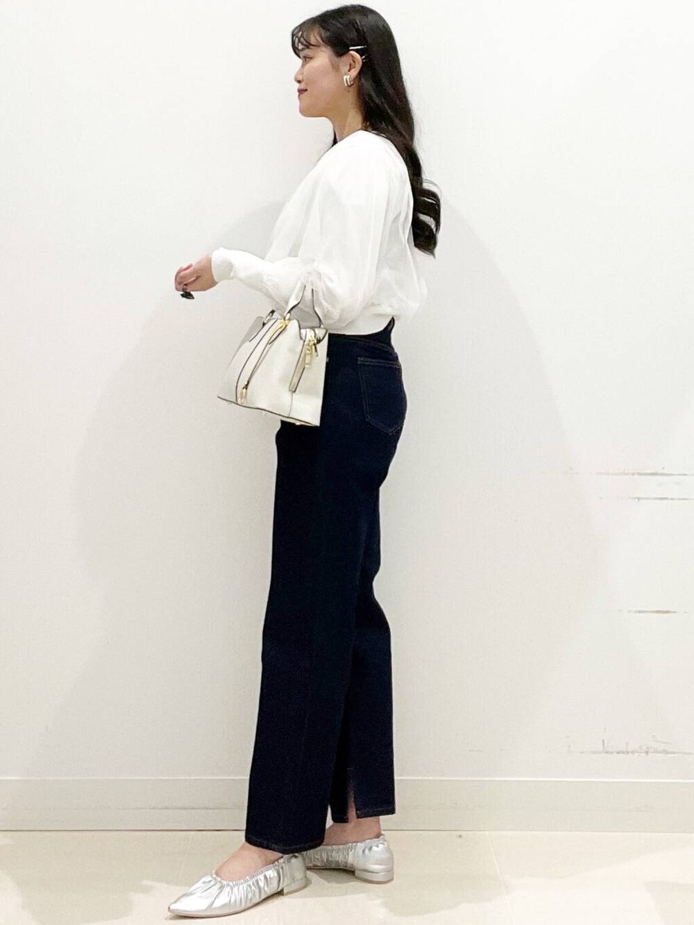 ブルー系のデニムパンツ、シルバー系のバレエシューズ、ホワイト系のカーディガン/ボレロを着用したレディースの春コーディネートの4枚目の写真