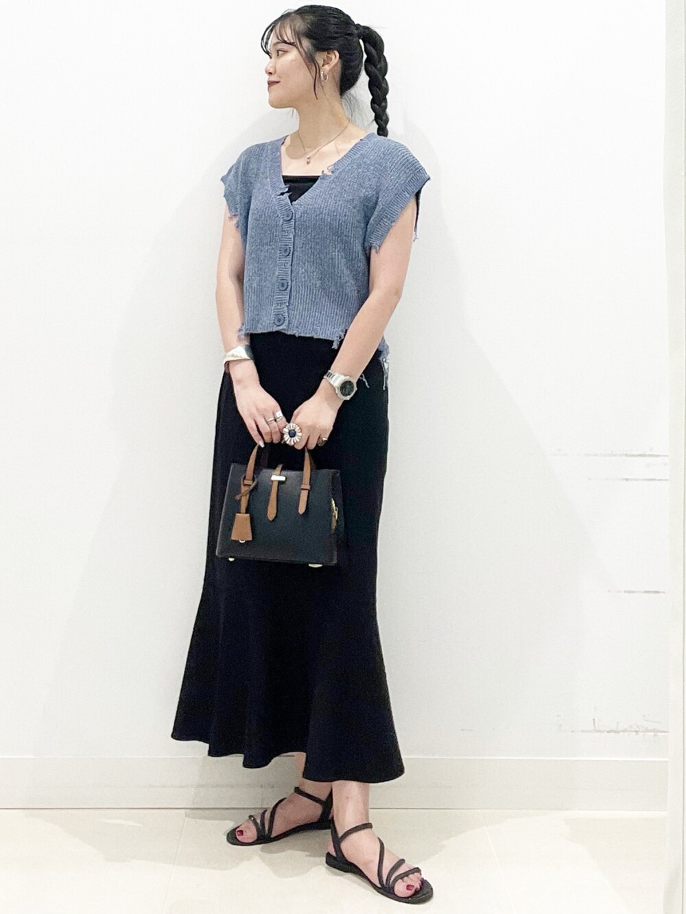 ブラック系のハンドバッグ、ブラック系のキャミソール、ブラック系のサンダルを着用したレディースの夏コーディネートの4枚目の写真