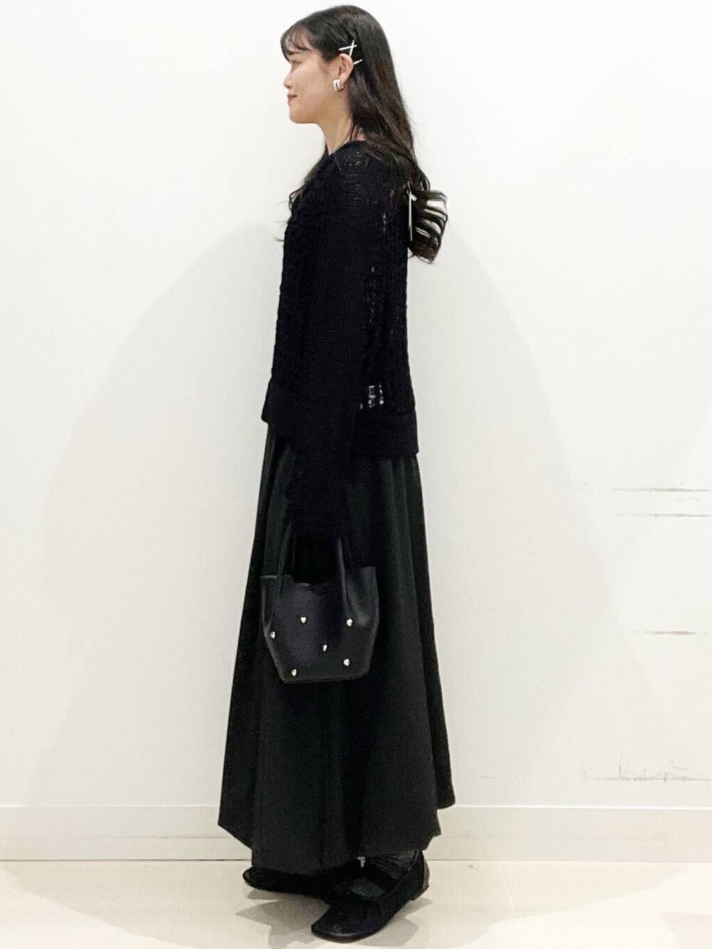 ブラック系のショルダーバッグ、ブラック系のスカート、ブラック系のニット/セーターを着用したレディースの春コーディネートの4枚目の写真