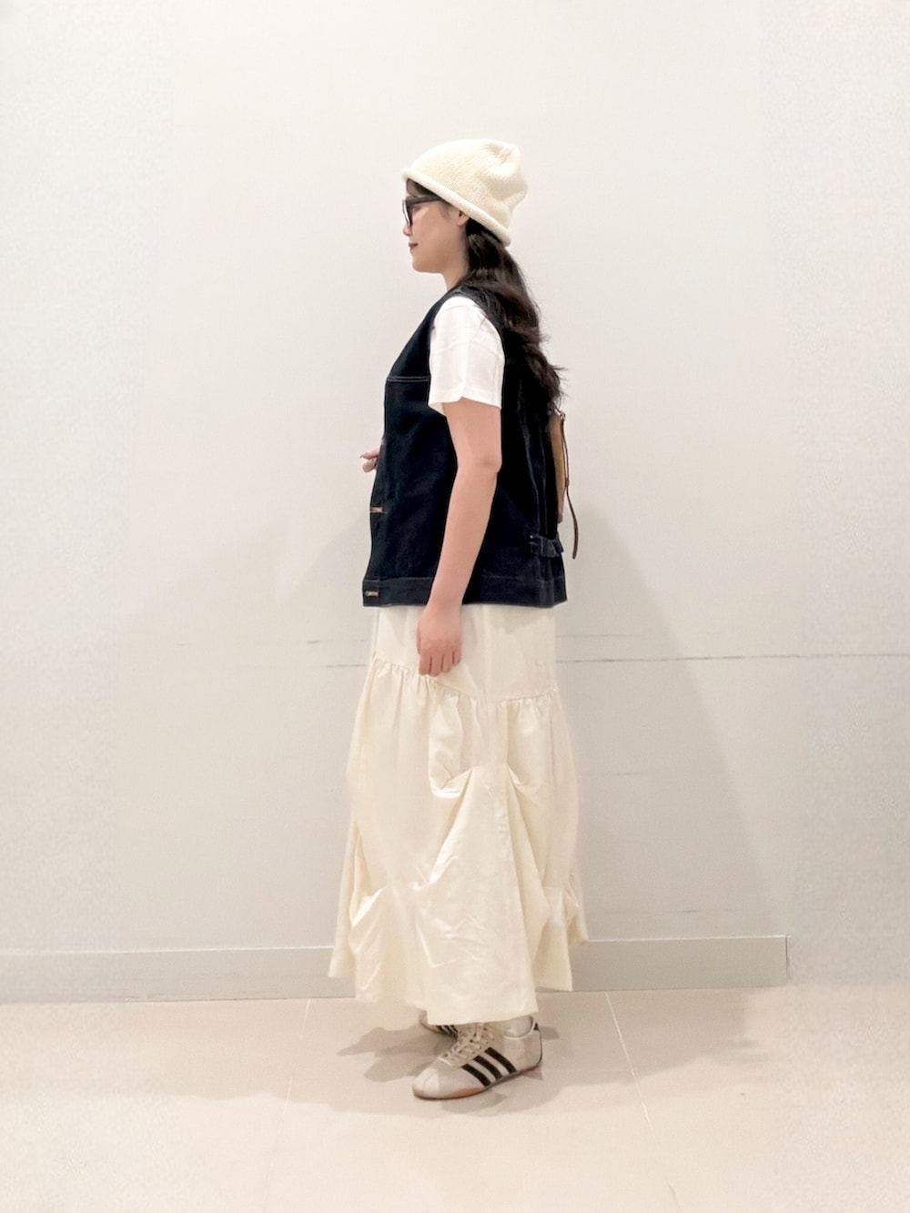 ホワイト系のTシャツ/カットソー、ブルー系のベスト、イエロー系のショルダーバッグを着用したレディースの秋コーディネートの3枚目の写真