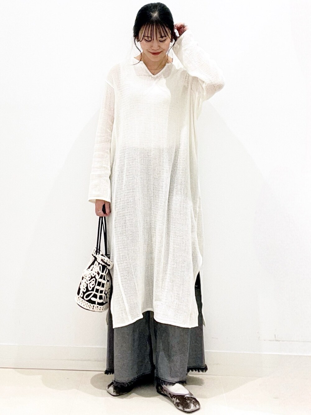 グレー系のバレエシューズ、ブラック系のデニムパンツ、ブラック系のハンドバッグを着用したレディースの秋コーディネートの3枚目の写真