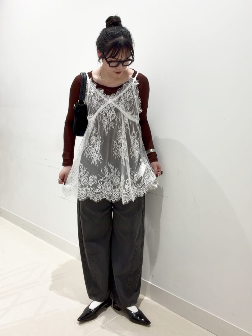 ブラウン系のTシャツ/カットソー、ホワイト系のキャミソール、グレー系のデニムパンツを着用したレディースの秋コーディネートの2枚目の写真