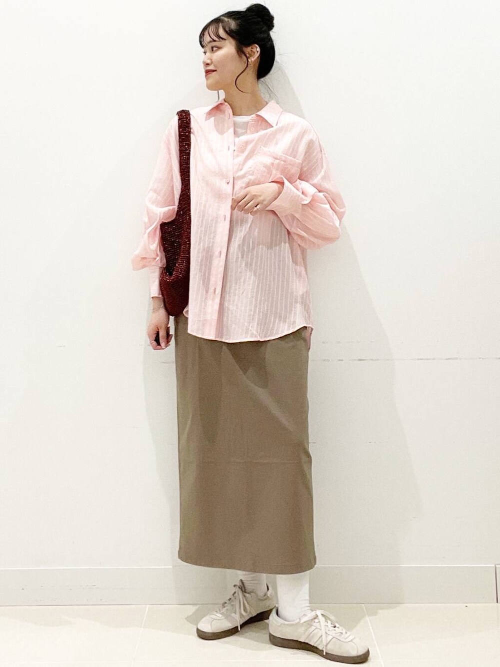 ホワイト系のスニーカー、ブラウン系のスカート、ホワイト系のキャミソールを着用したレディースの春コーディネートの4枚目の写真