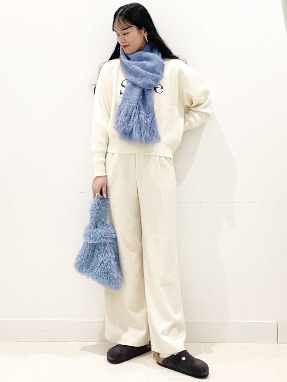ブルー系のハンドバッグ、ホワイト系のその他パンツ、ホワイト系のニット/セーターを着用したレディースの冬コーディネートの5枚目の写真