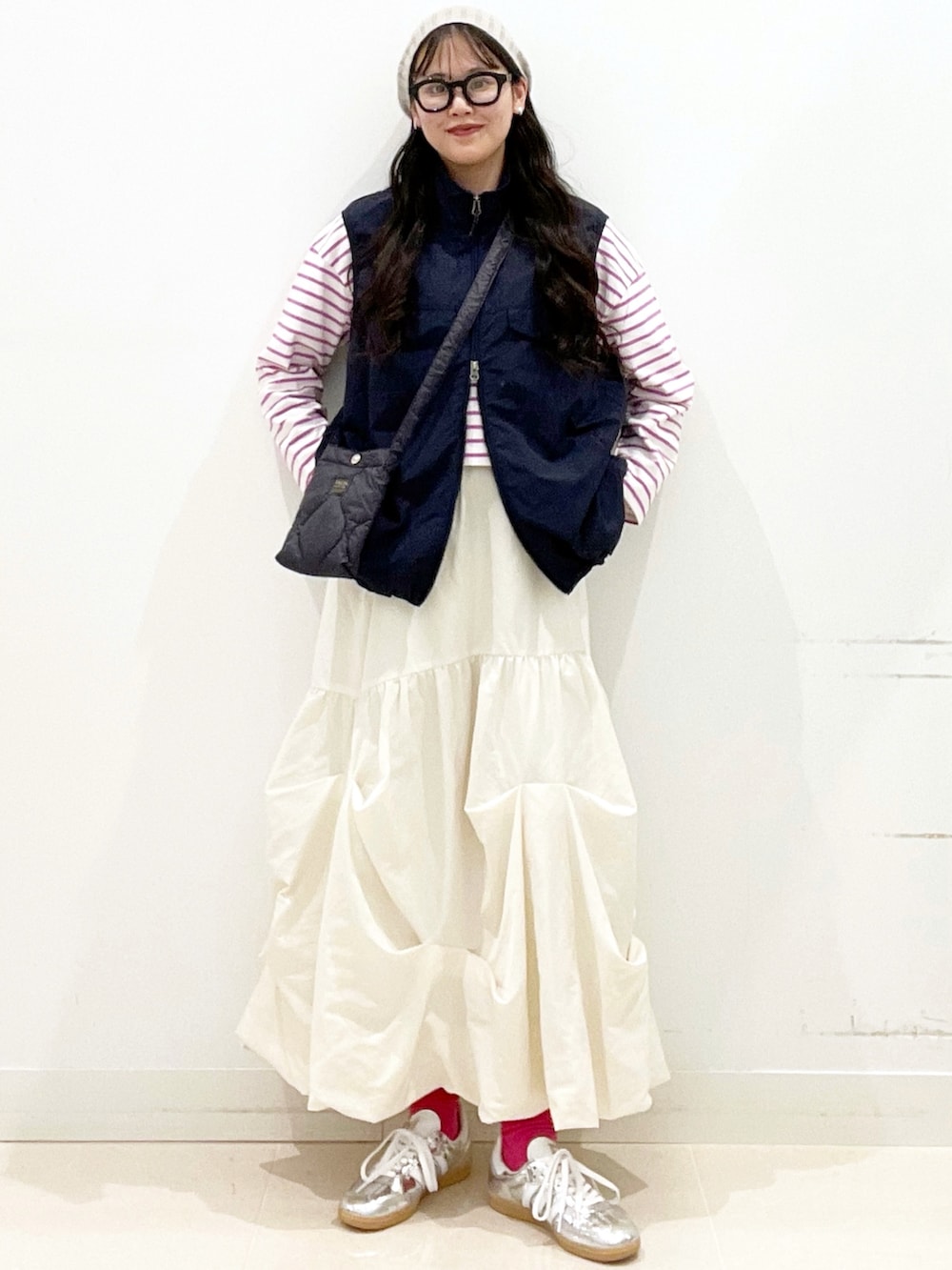 シルバー系のスニーカー、ホワイト系のスカート、ブルー系のナイロンジャケットを着用したレディースの春コーディネートの2枚目の写真