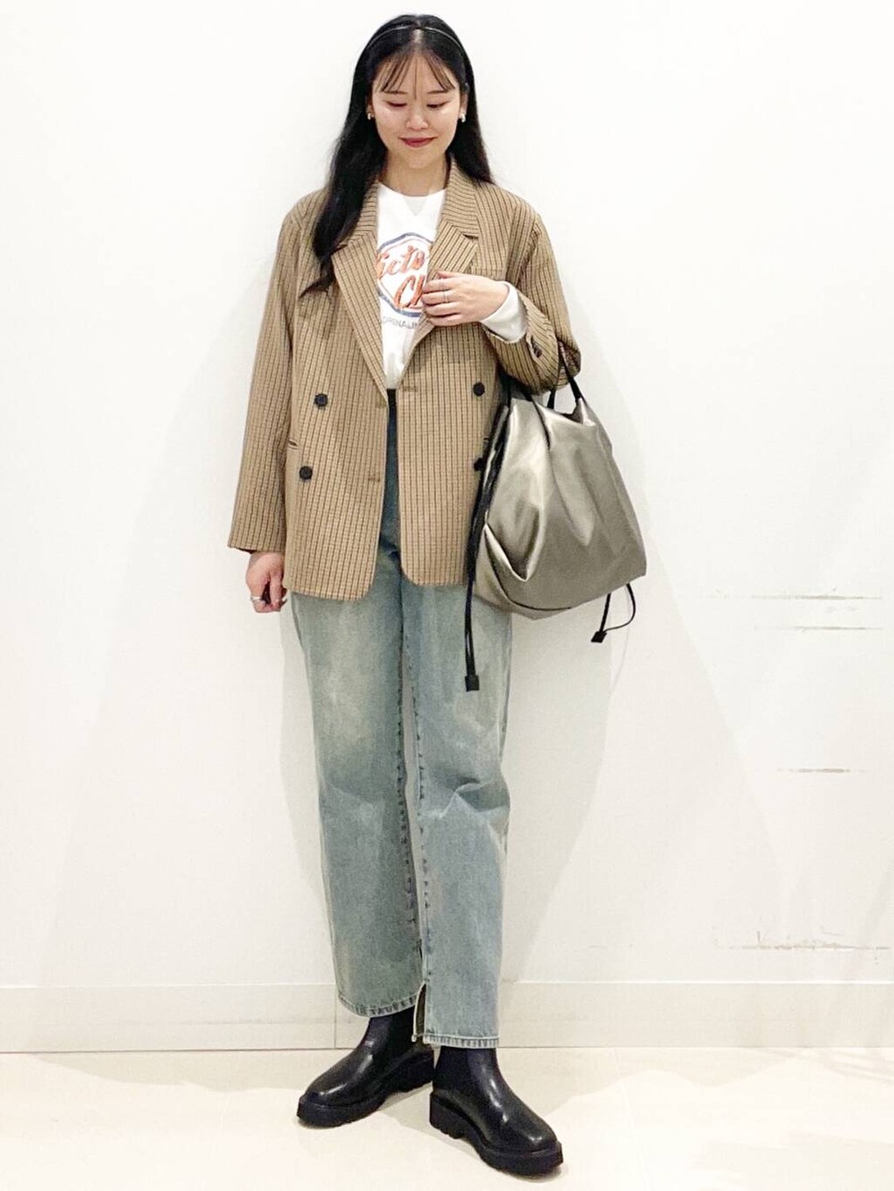 シルバー系のトートバッグ、ブルー系のその他パンツ、ブラック系のブーツを着用したレディースの秋コーディネートの6枚目の写真
