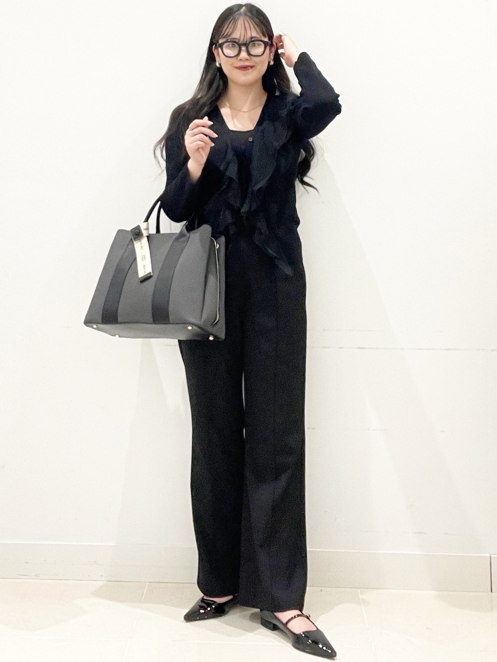 ブラック系のパンプス、ブラック系のトートバッグ、ブラック系のキャミソールを着用したレディースの冬コーディネートの2枚目の写真