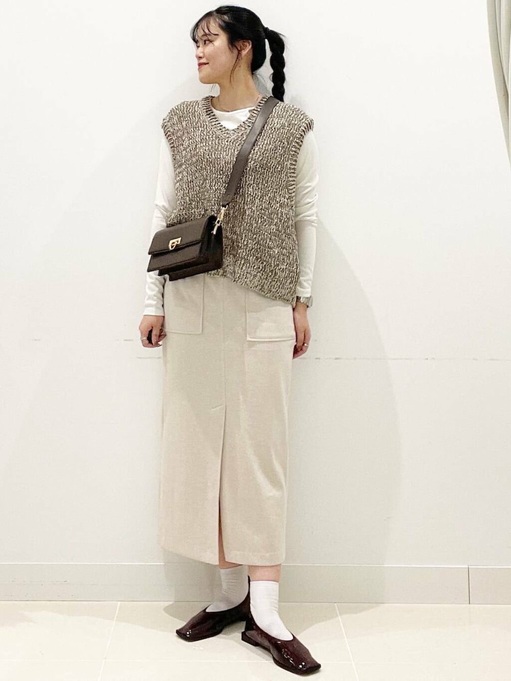 ブラウン系のショルダーバッグ、レッド系のバレエシューズ、ホワイト系のTシャツ/カットソーを着用したレディースの秋コーディネートの2枚目の写真