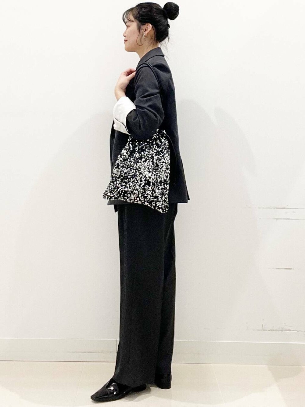 シルバー系のトートバッグ、グレー系のテーラードジャケット、グレー系のその他パンツを着用したレディースの冬コーディネートの5枚目の写真