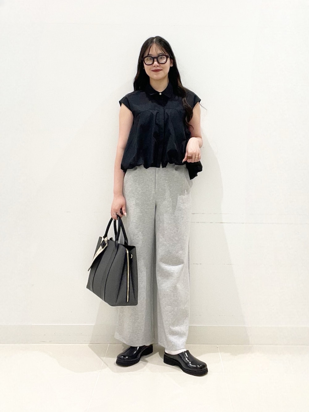 ブラック系のシャツ/ブラウス、グレー系のその他パンツ、ブラック系のサンダルを着用したレディースの夏コーディネートの2枚目の写真