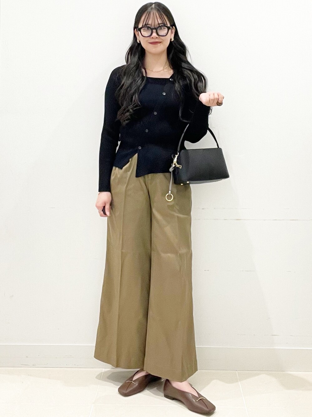 ブラウン系のその他シューズ、ベージュ系のその他パンツ、ブラック系のショルダーバッグを着用したレディースの冬コーディネートの4枚目の写真