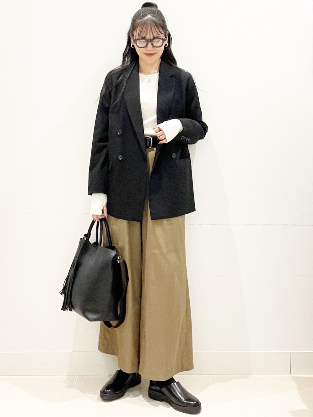 ベージュ系のその他パンツ、ブラック系のトートバッグ、ブラック系のその他アウターを着用したレディースの秋コーディネートの4枚目の写真