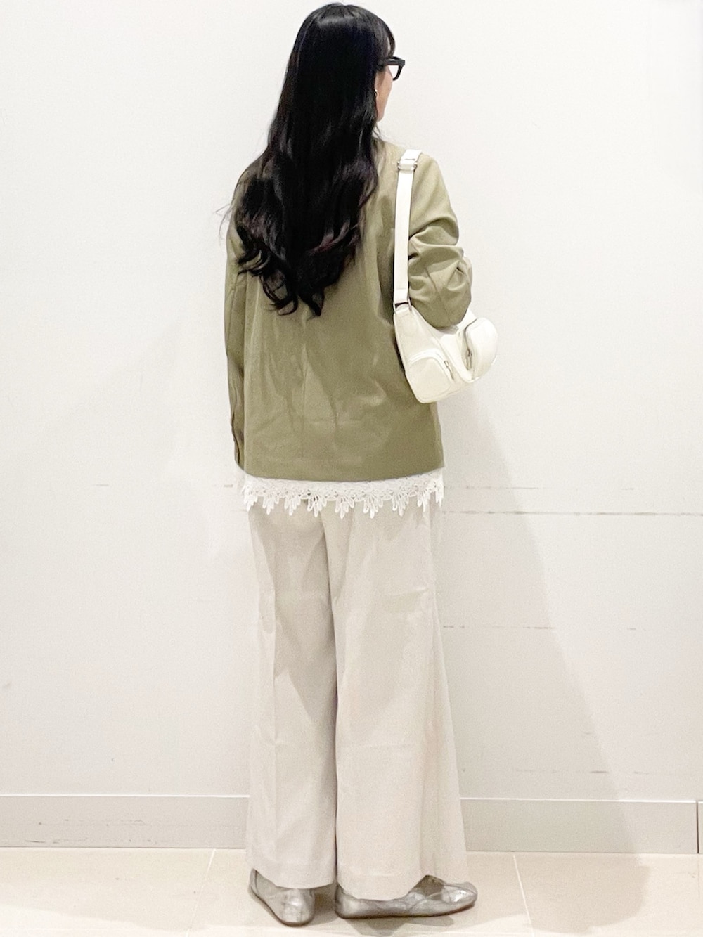 ホワイト系のチノパンツ、ベージュ系のノーカラージャケット、ホワイト系のショルダーバッグを着用したレディースの春コーディネートの7枚目の写真