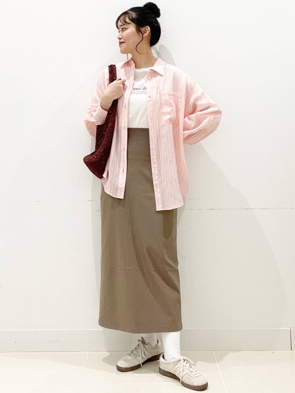 ホワイト系のスニーカー、ブラウン系のスカート、ホワイト系のキャミソールを着用したレディースの春コーディネートの2枚目の写真