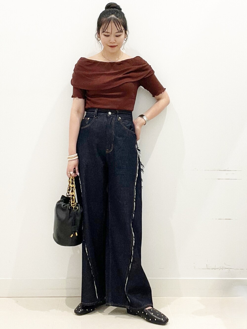 ブルー系のデニムパンツ、ブラック系のショルダーバッグ、ブラック系のパンプスを着用したレディースの夏コーディネートの4枚目の写真