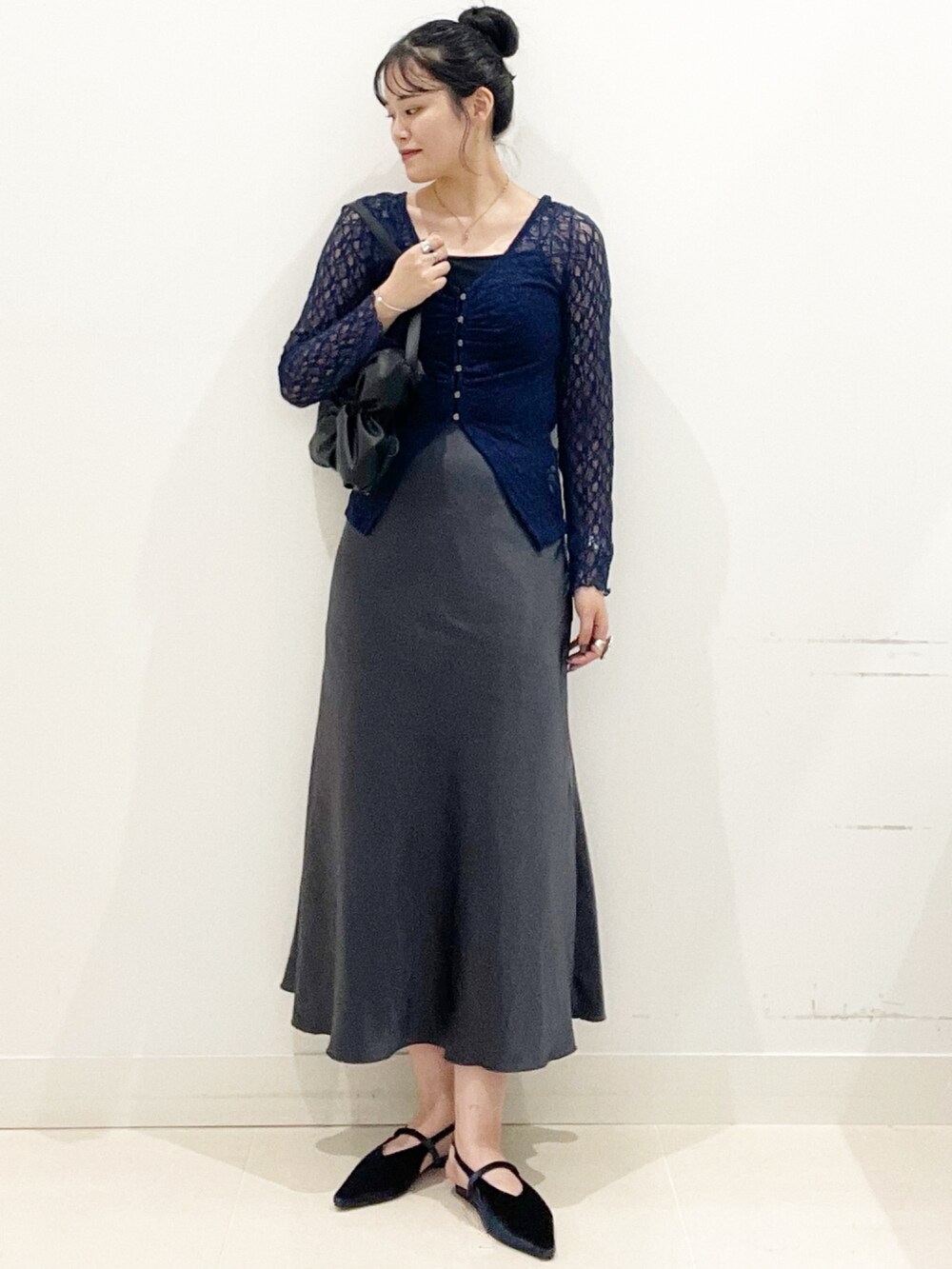 ブラック系のキャミソール、ブラック系のハンドバッグ、ブルー系のパンプスを着用したレディースの秋コーディネートの4枚目の写真