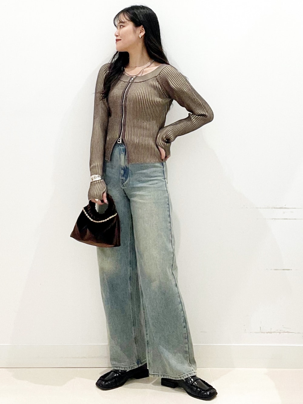 ブラウン系のハンドバッグ、ブラック系のローファー、ブラウン系のニット/セーターを着用したレディースの秋コーディネートの2枚目の写真