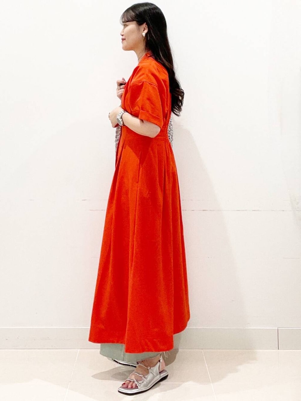 シルバー系のハンドバッグ、ホワイト系のキャミソール、レッド系のワンピースを着用したレディースの夏コーディネートの5枚目の写真