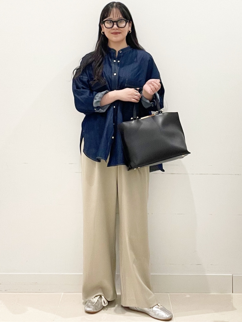 ベージュ系のスラックス、ブラック系のトートバッグ、ブルー系のシャツ/ブラウスを着用したレディースの春コーディネートの3枚目の写真
