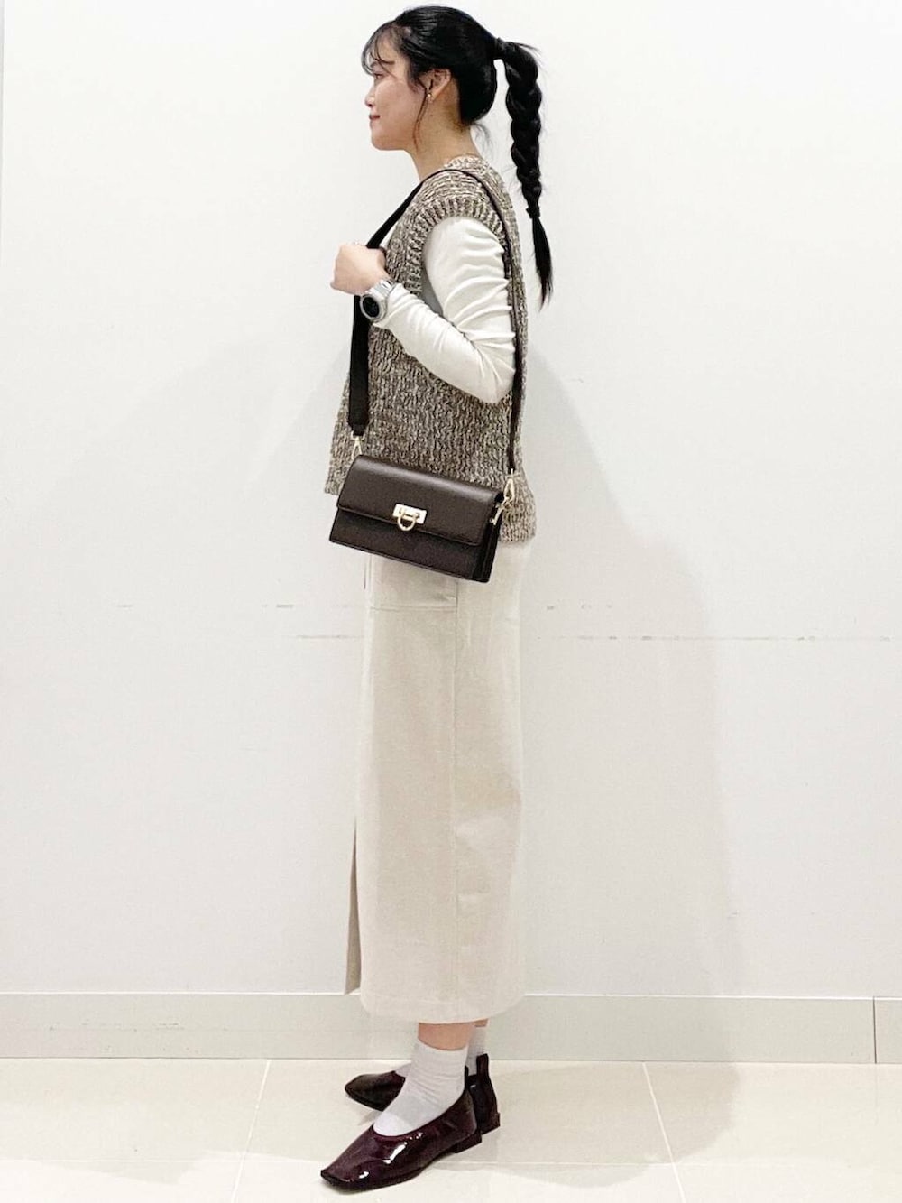 ブラウン系のショルダーバッグ、レッド系のバレエシューズ、ホワイト系のTシャツ/カットソーを着用したレディースの秋コーディネートの5枚目の写真