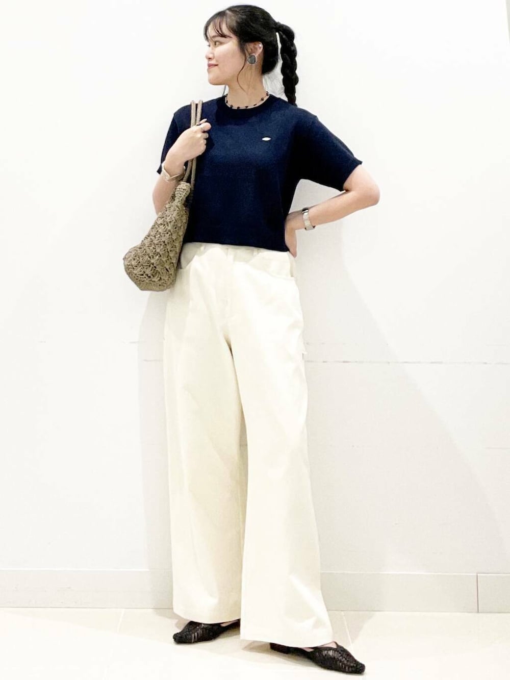 グレー系のトートバッグ、ブラック系のサンダル、ブルー系のニット/セーターを着用したレディースの夏コーディネートの2枚目の写真