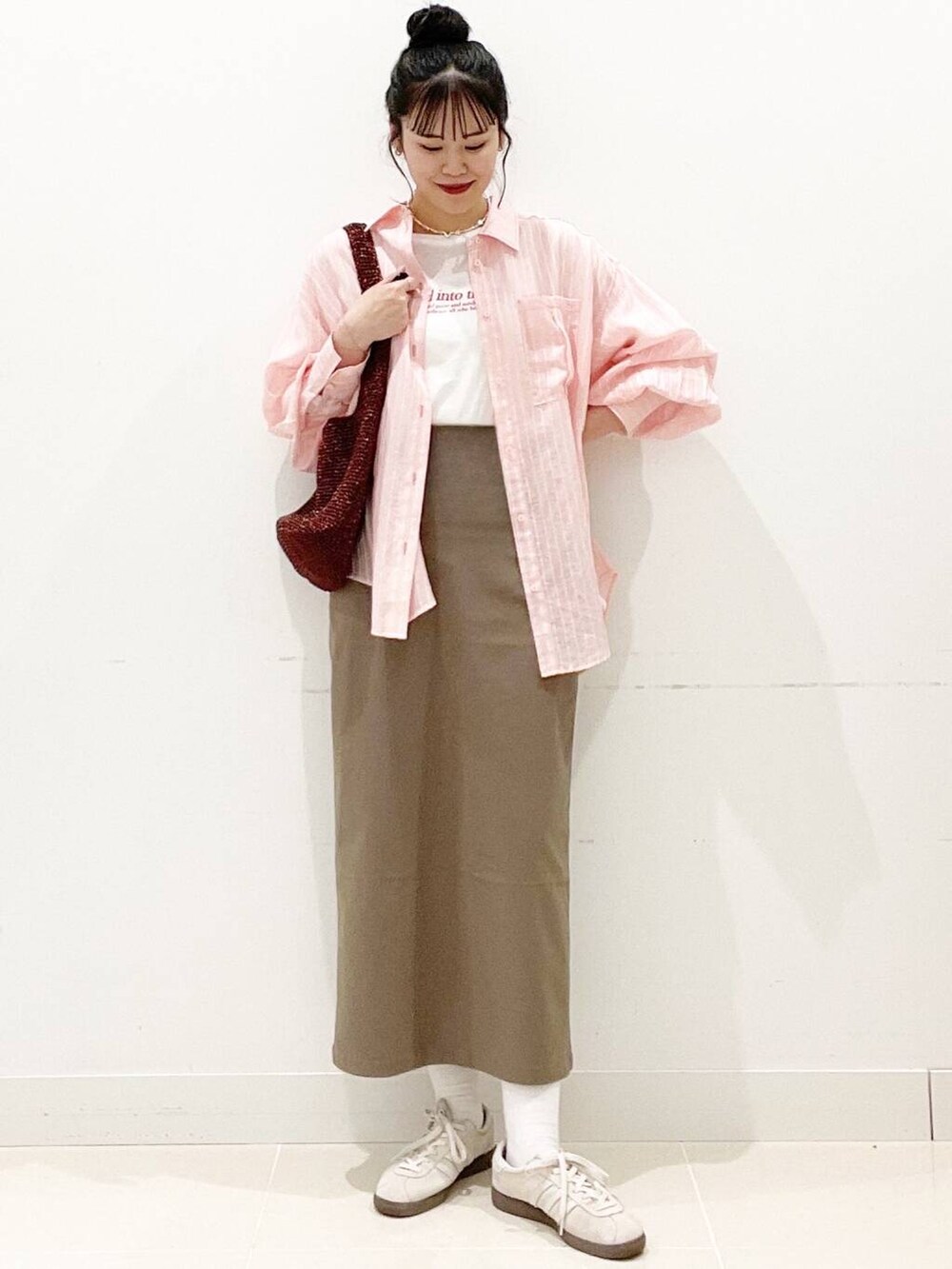 ホワイト系のスニーカー、ブラウン系のスカート、ホワイト系のキャミソールを着用したレディースの春コーディネートの5枚目の写真