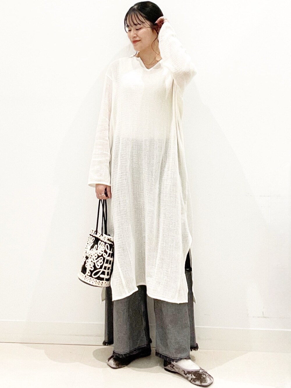 グレー系のバレエシューズ、ブラック系のデニムパンツ、ブラック系のハンドバッグを着用したレディースの秋コーディネートの2枚目の写真