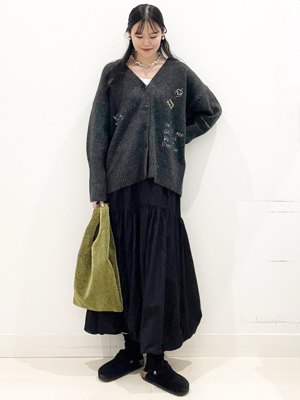 ホワイト系のTシャツ/カットソー、ゴールド系のトートバッグ、ブラック系のスカートを着用したレディースの秋コーディネートの5枚目の写真