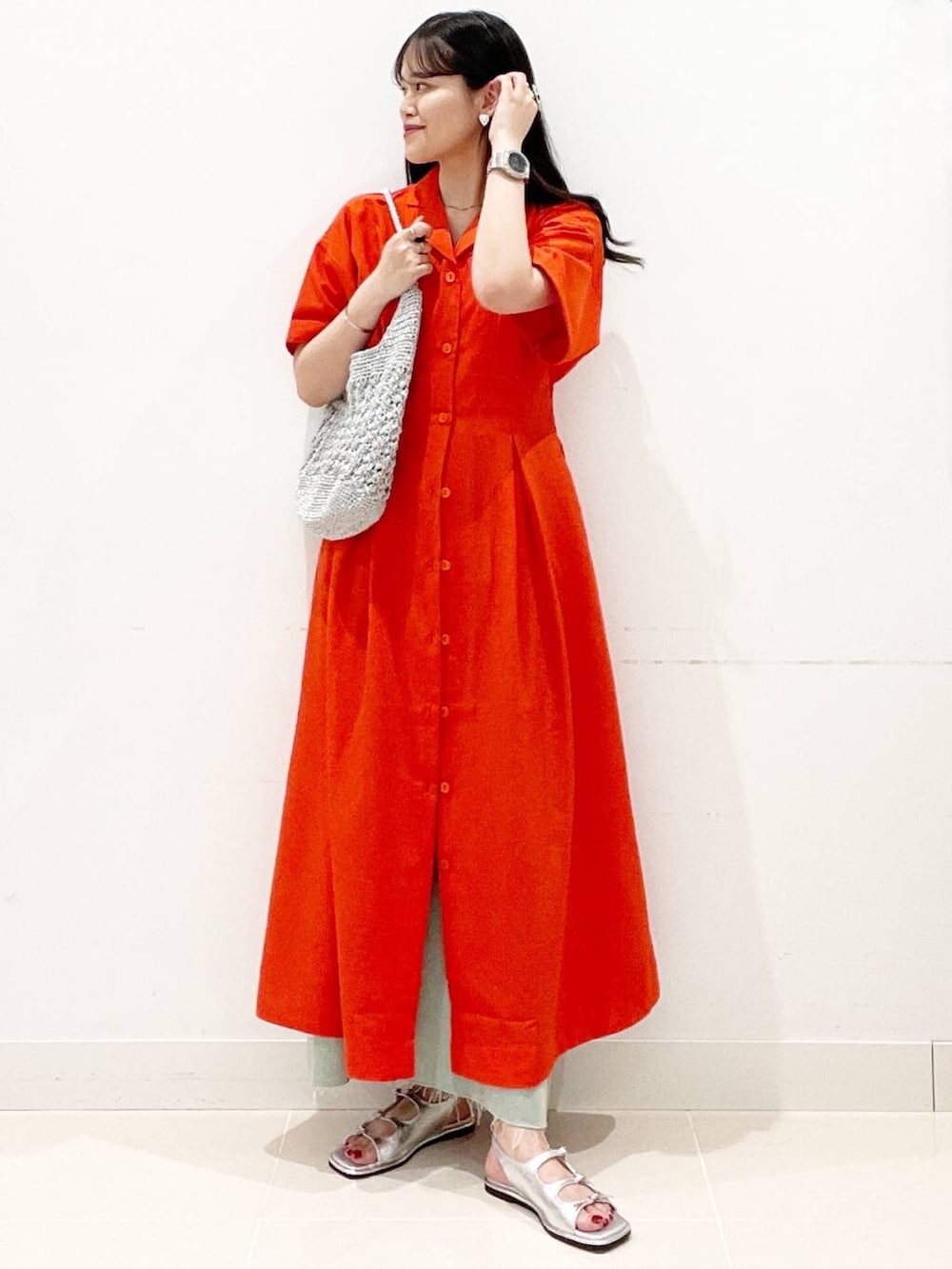 シルバー系のハンドバッグ、ホワイト系のキャミソール、レッド系のワンピースを着用したレディースの夏コーディネートの3枚目の写真