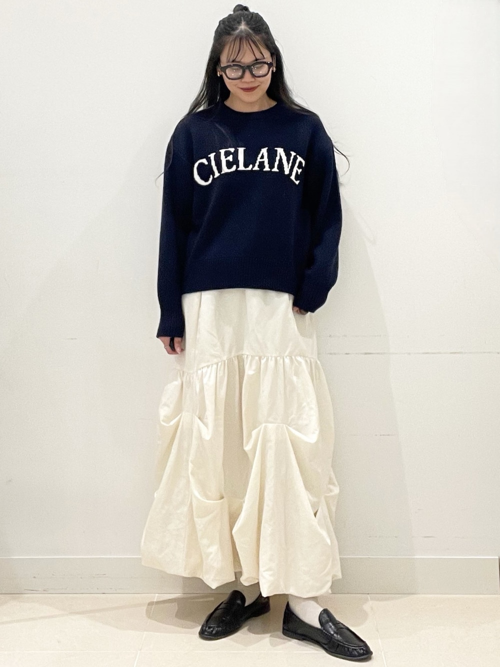 ホワイト系のスカート、ブラック系のボストンバッグ、ブルー系のニット/セーターを着用したレディースの冬コーディネートの4枚目の写真