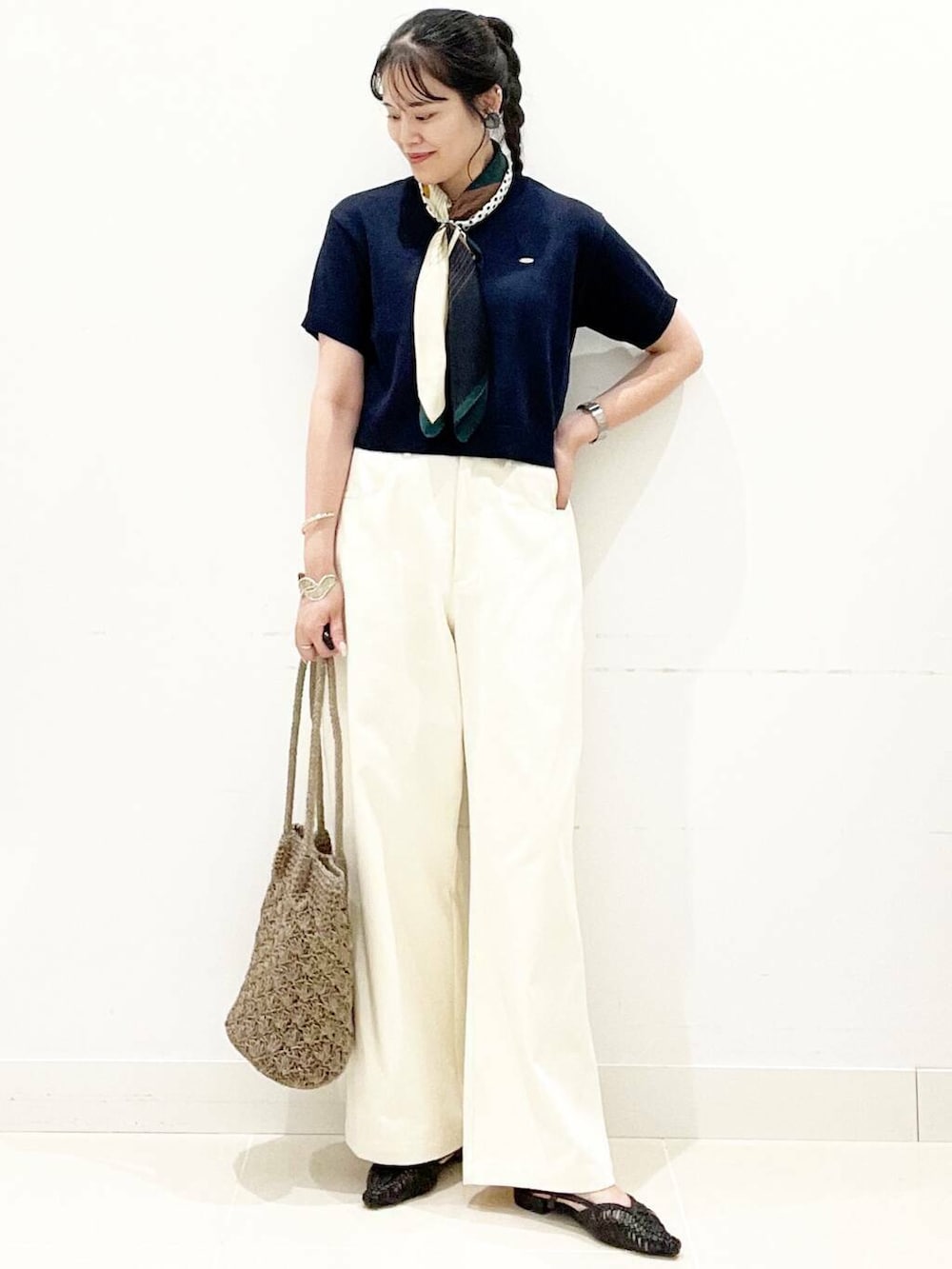 グレー系のトートバッグ、ブラック系のサンダル、ブルー系のニット/セーターを着用したレディースの夏コーディネートの3枚目の写真