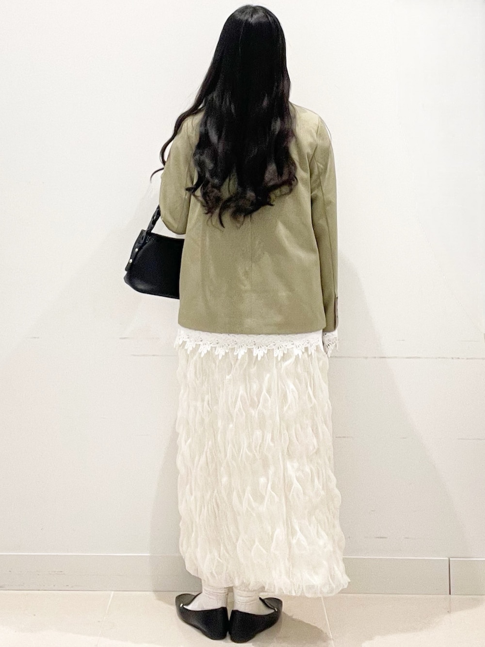 ブラック系のローファー、ホワイト系のスカート、ベージュ系のノーカラージャケットを着用したレディースの春コーディネートの6枚目の写真