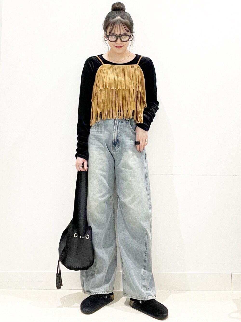 ブラック系のサンダル、ブラック系のショルダーバッグ、ブルー系のデニムパンツを着用したレディースの秋コーディネートの4枚目の写真