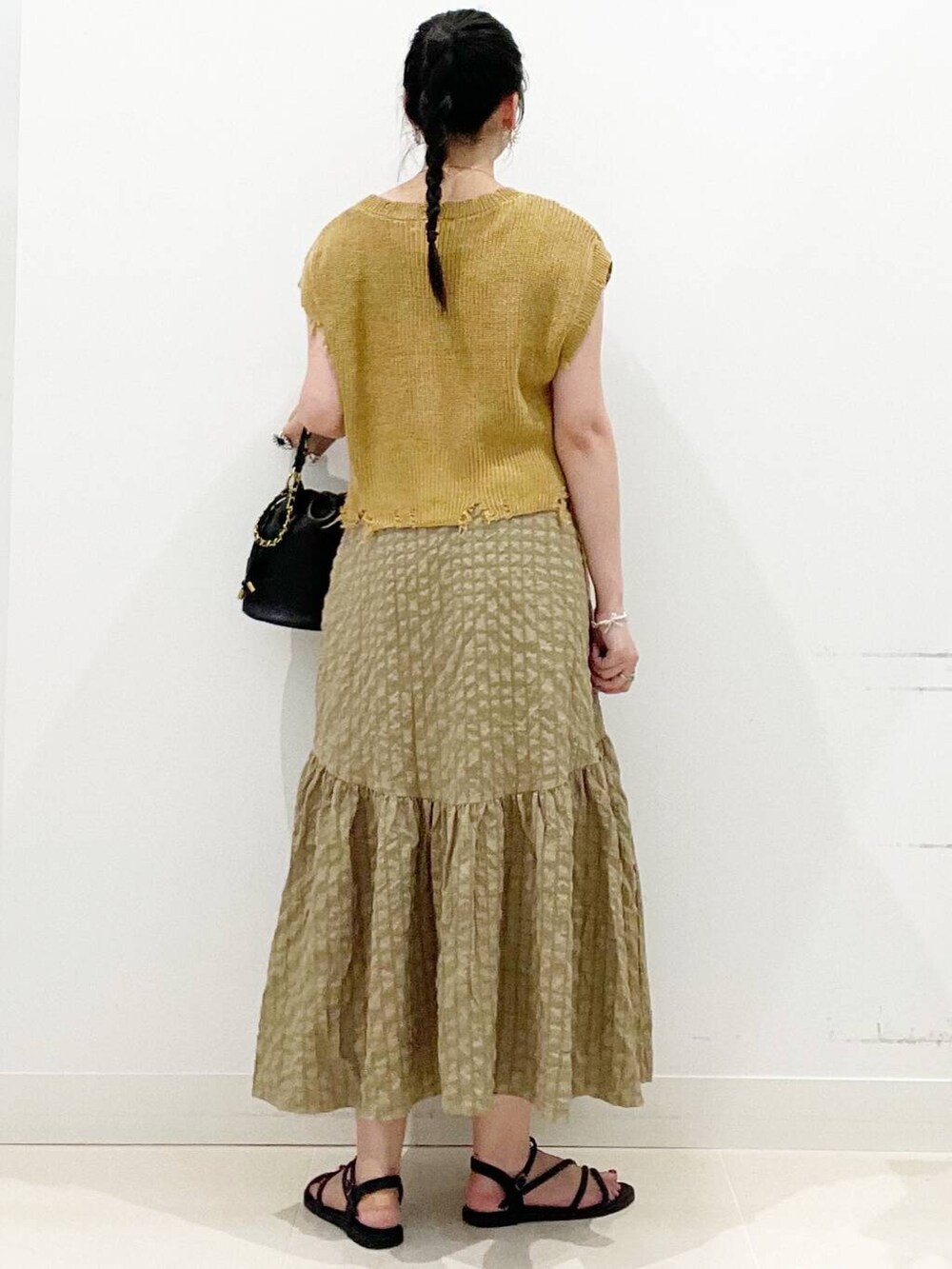 ホワイト系のキャミソール、グリーン系のスカート、ブラック系のサンダルを着用したレディースの夏コーディネートの8枚目の写真