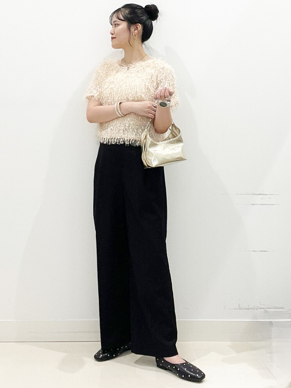 ゴールド系のハンドバッグ、ブラック系のパンプス、オレンジ系のその他トップスを着用したレディースの夏コーディネートの3枚目の写真