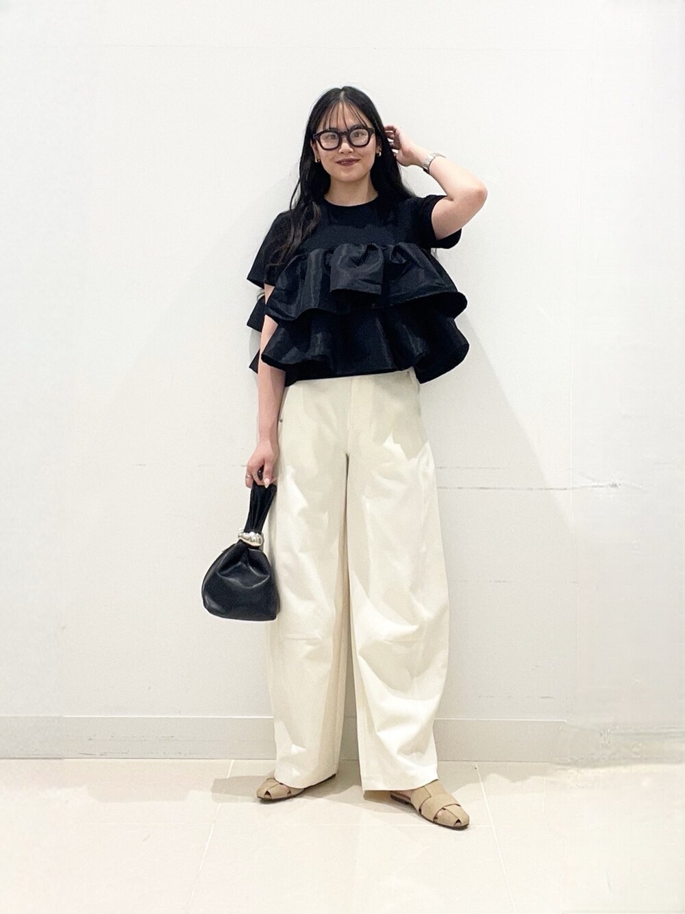 ブラック系のTシャツ/カットソー、ブラック系のハンドバッグ、ホワイト系のその他パンツを着用したレディースの夏コーディネートの2枚目の写真