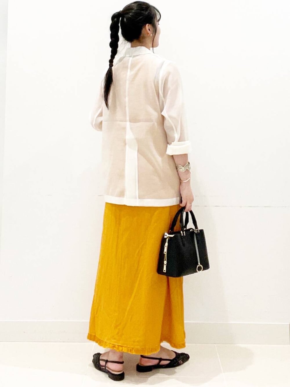 ブラック系のハンドバッグ、ブラック系のサンダル、ホワイト系のその他アウターを着用したレディースの夏コーディネートの7枚目の写真