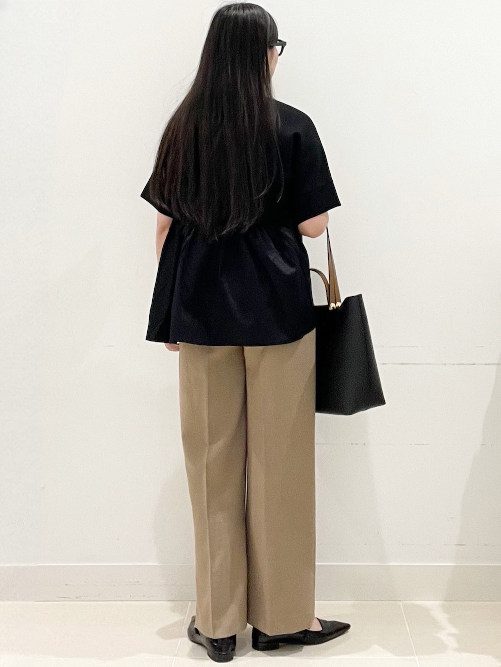 ブラック系のパンプス、ベージュ系のその他パンツ、ブラック系のTシャツ/カットソーを着用したレディースの春コーディネートの6枚目の写真