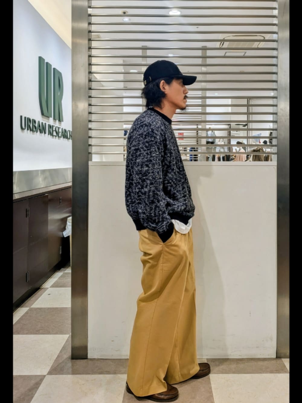 ブラック系のニット/セーター、ベージュ系のその他パンツ、ホワイト系のTシャツ/カットソーを着用したメンズの秋コーディネートの3枚目の写真