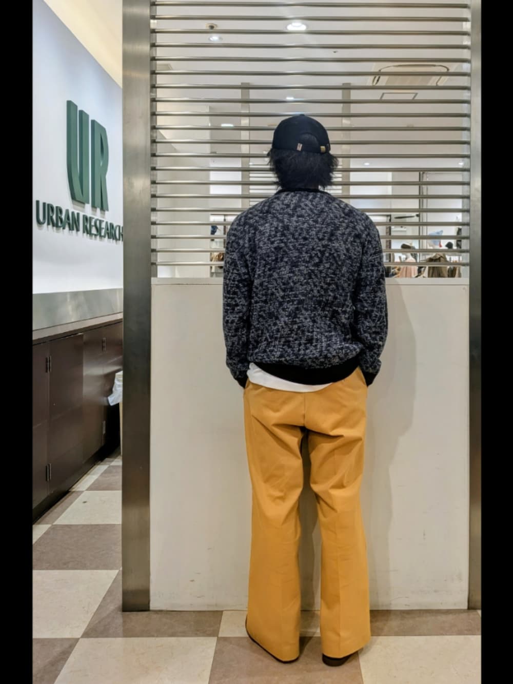 ブラック系のニット/セーター、ベージュ系のその他パンツ、ホワイト系のTシャツ/カットソーを着用したメンズの秋コーディネートの4枚目の写真