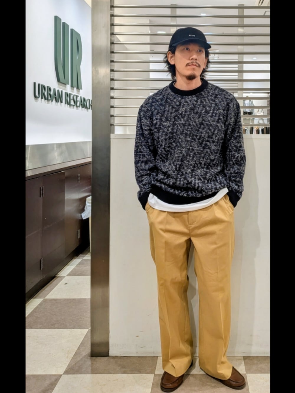 ブラック系のニット/セーター、ベージュ系のその他パンツ、ホワイト系のTシャツ/カットソーを着用したメンズの秋コーディネートの2枚目の写真