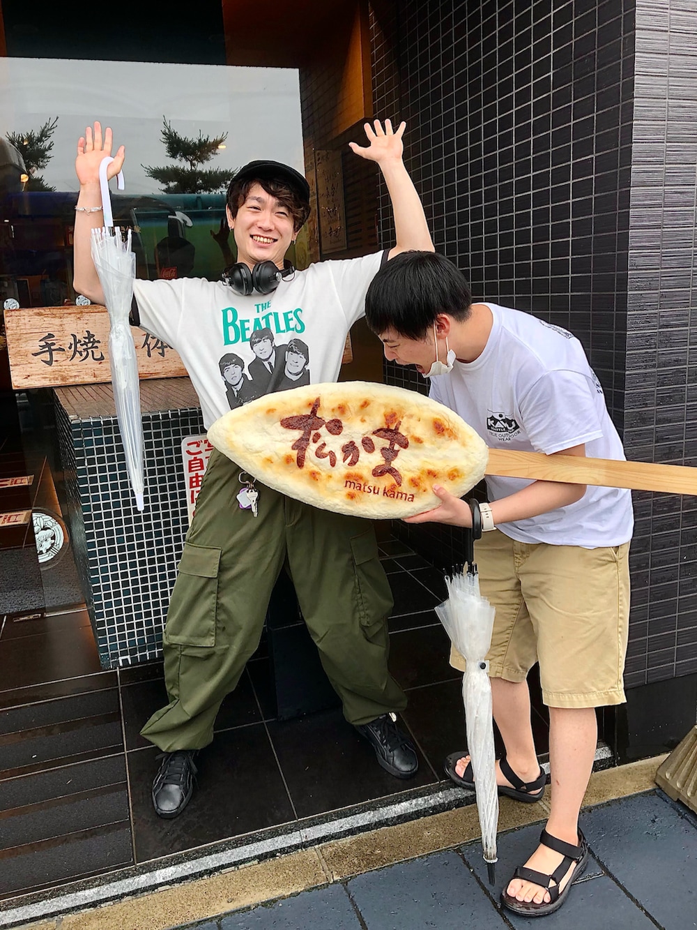 ホワイト系のTシャツ/カットソー、グリーン系のカーゴパンツ、ブラック系のスニーカーを着用したメンズの夏コーディネートの2枚目の写真