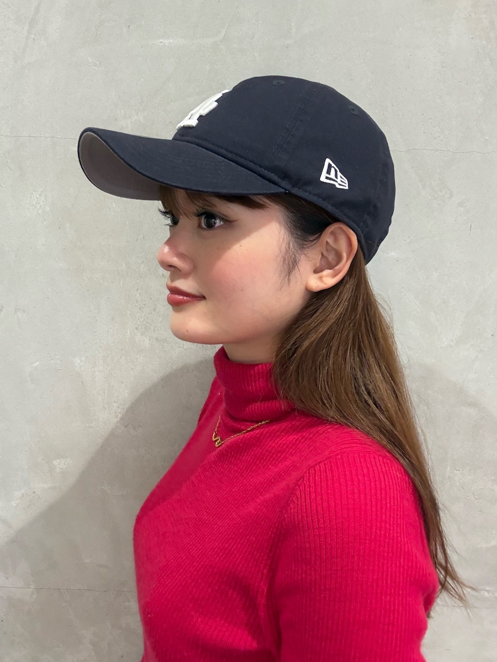 ブルー系のキャップ、ブラック系のキャップ、ベージュ系のキャップを着用したレディースの春コーディネートの3枚目の写真