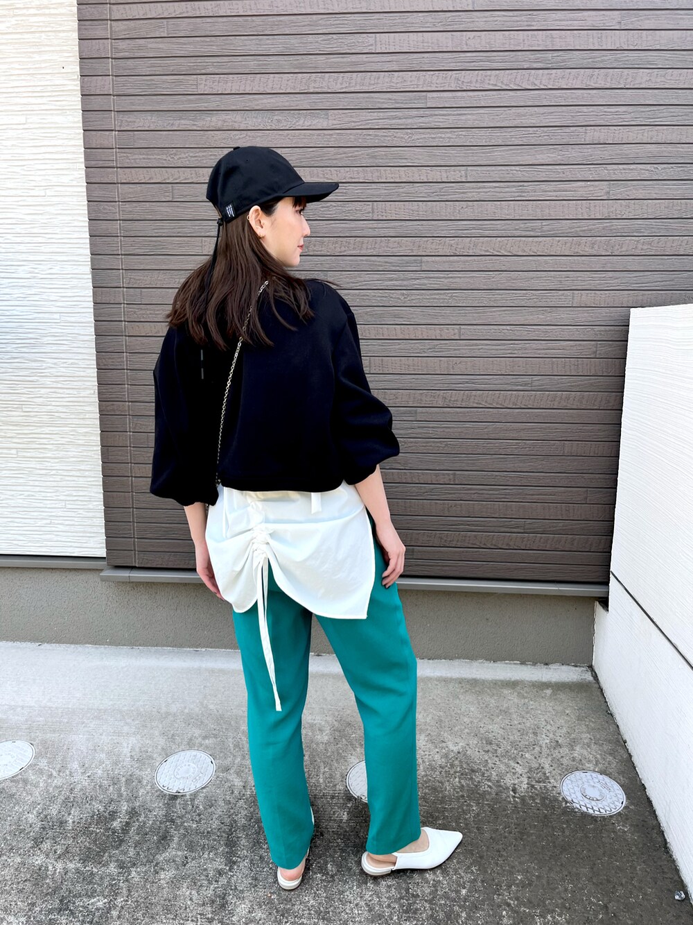 ブラック系のTシャツ/カットソー、グリーン系のパンツ、ホワイト系のシューズを着用したレディースの春コーディネートの2枚目の写真